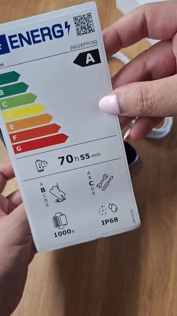 Label tenaga Xiaomi 17T Pro dipegang di tangan: penarafan kelas A, 70 jam 55 minit penggunaan per satu cas, 1,000 kitaran cas dan IP68