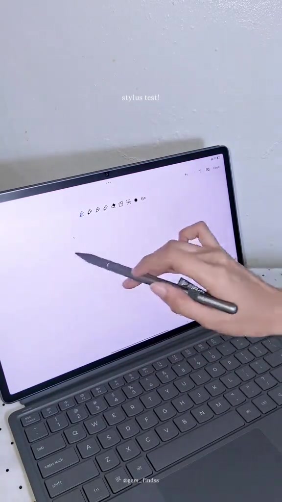 Tangan menulis pada skrin Idea Tab Pro Gen 2 menggunakan stylus dengan keyboard folio kelihatan di bawah