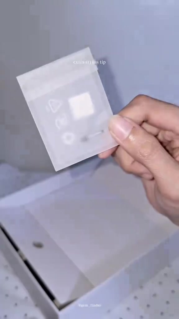 Paket kecil berisi tip ganti stylus dipegang di atas kotak tablet