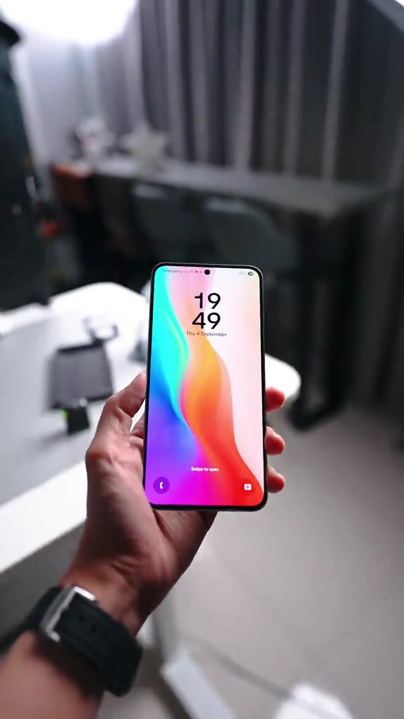 Galaxy S25 FE dipegang sebelah tangan dengan skrin kunci menyala