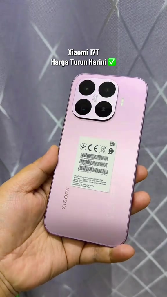 Bahagian belakang Xiaomi 17T warna merah jambu dengan label pengeluar berbarcode masih melekat, menunjukkan unit baru set rasmi
