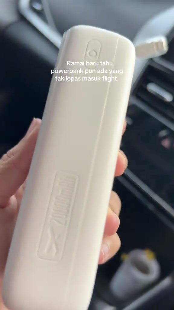 Sisi power bank putih dengan tanda timbul 20000mAh dan simbol kapal terbang