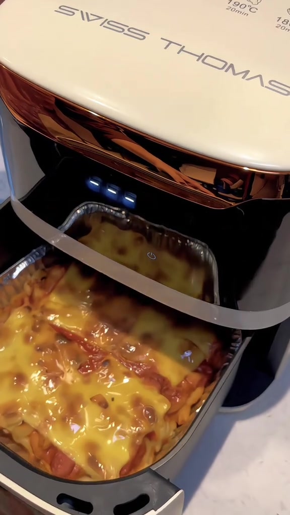 Bakul air fryer Swiss Thomas ditarik keluar menunjukkan hidangan berlapis keju dengan panduan suhu 190 darjah 20 minit pada badan mesin