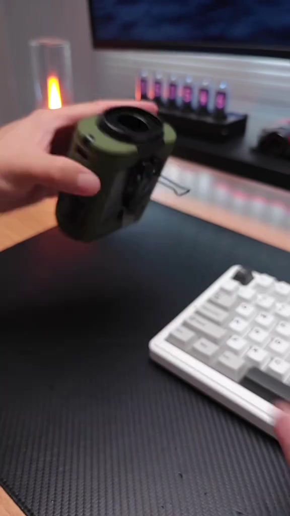 Tangan memegang kipas waist portable hijau zaiton dengan klip di atas meja hitam