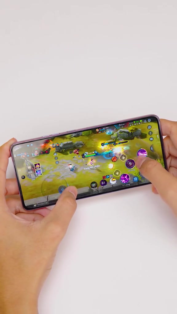 Hai tay cầm ngang chiếc điện thoại khung màu tím chơi game Liên Quân Mobile trên nền trắng
