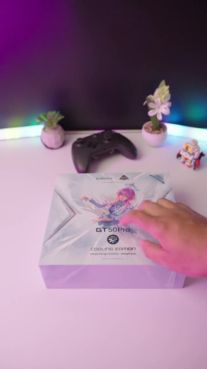 Kotak jualan Infinix GT 50 Pro Cooling Edition di atas meja bersama gamepad, dengan label Magcharge Cooler dan MagCase pada hadapan kotak