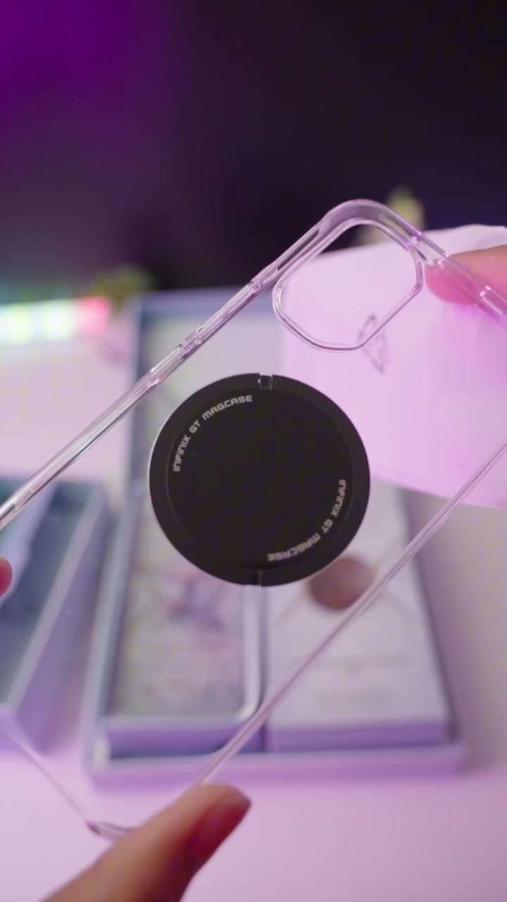 MagCase lutsinar Infinix GT 50 Pro dengan cincin magnetik hitam GT MagCase dipegang dua tangan