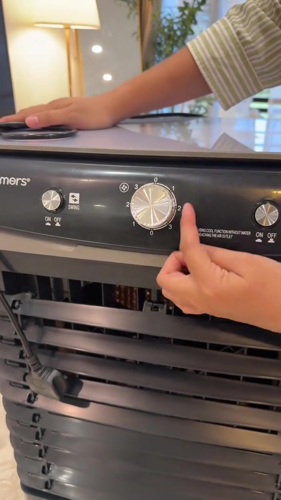 Panel kawalan air cooler Hulmers dengan knob swing, knob speed 0 hingga 3 dan suis cool, tangan sedang menunjuk knob speed