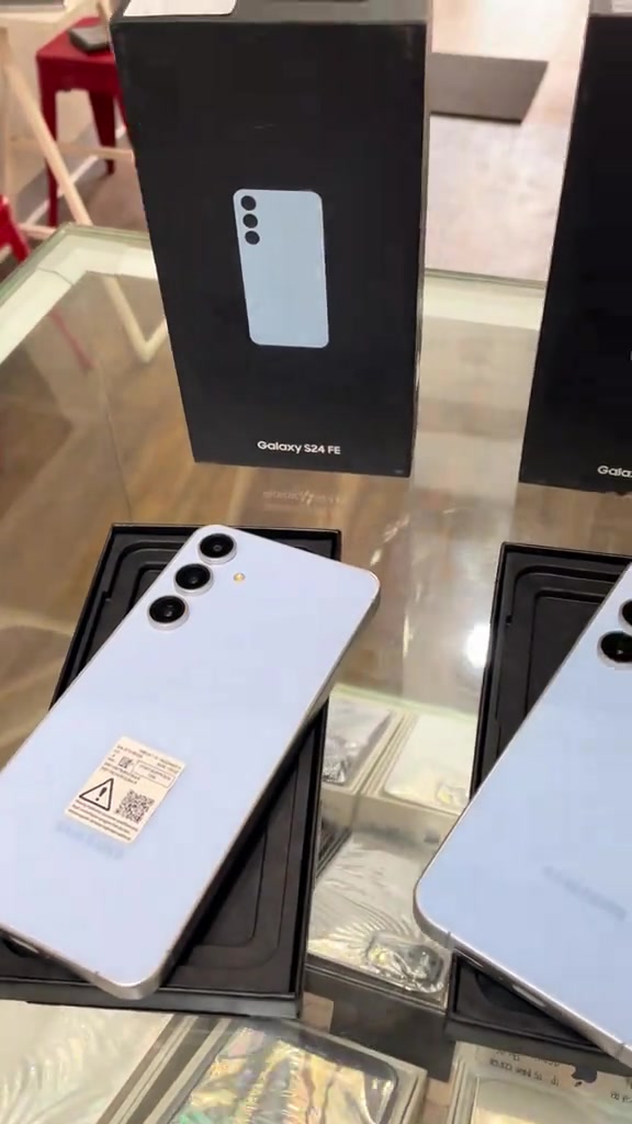 Unit terpakai Samsung Galaxy S24 FE warna biru muda diletakkan di atas kotak asal dalam kabinet pameran kedai