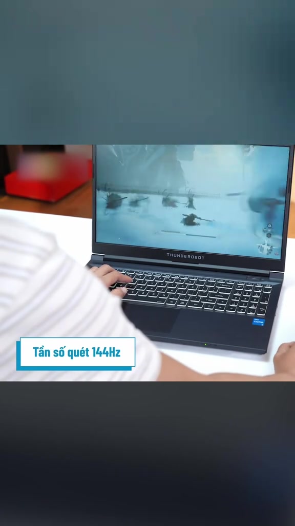 Người dùng đặt tay gõ phím trên Thunderobot Gaming 911S đang chạy game, kèm chú thích tần số quét 144Hz