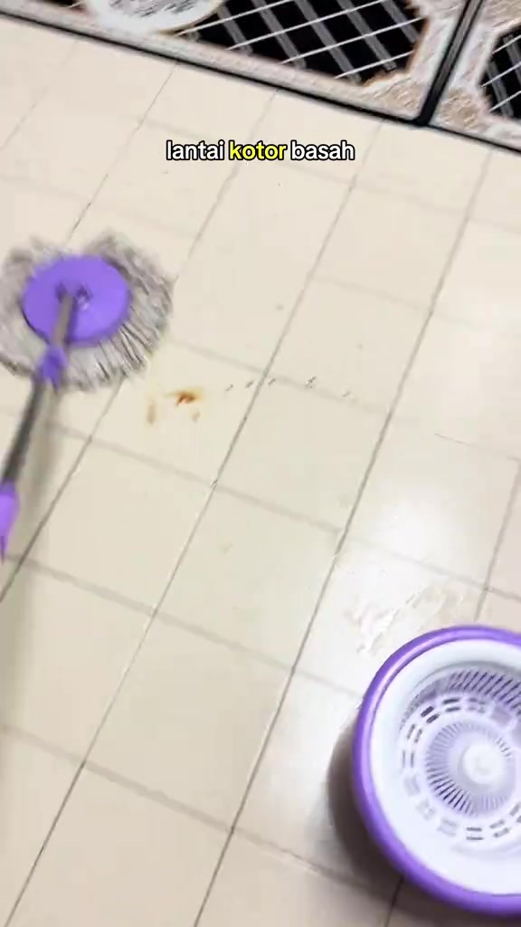 Kepala mop bulat sedang mengemop lantai jubin yang kotor dan basah