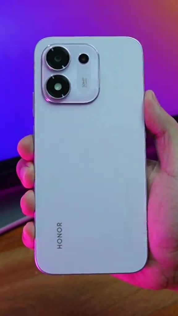Bahagian belakang Honor 600S warna cerah dengan modul dua kamera dan logo HONOR, dipegang di tangan