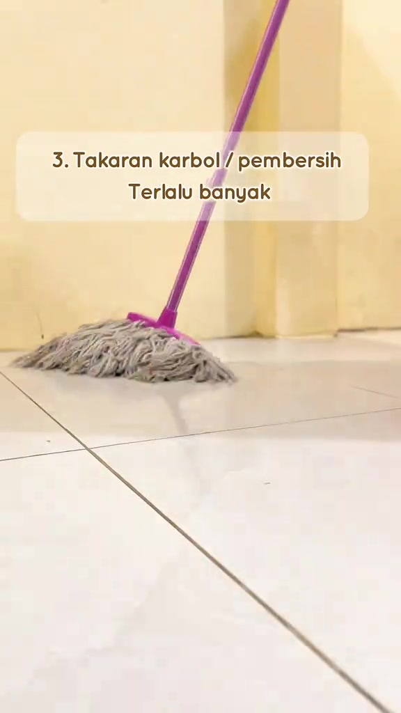 Mop tali berwarna kelabu berdiri atas lantai jubin putih