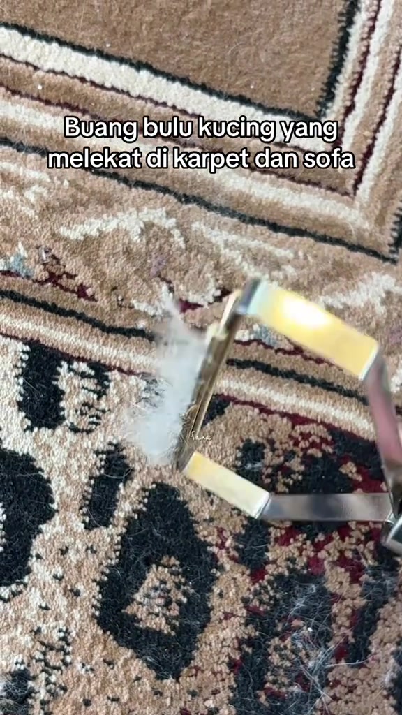 Alat penanggal bulu bingkai logam mengangkat gumpalan bulu putih daripada karpet bercorak