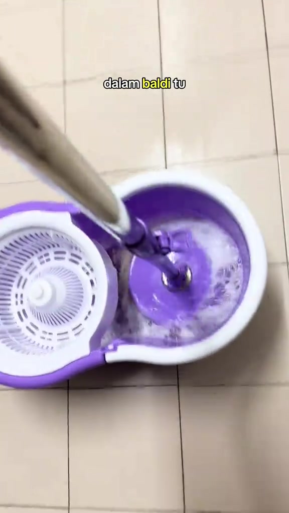 Batang mop dimasukkan ke dalam baldi spin berisi air berbuih
