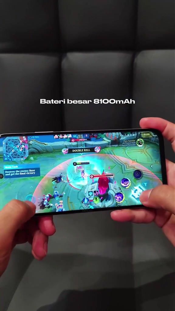 Honor 600S dipegang mendadak dua tangan sedang menjalankan game MOBA pada skrin