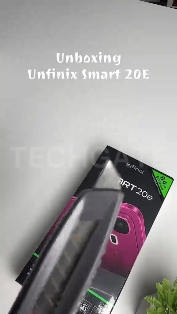 Kotak Infinix Smart 20e sedang dibuka dengan cutter, nampak kotak hitam dengan gambar fon merah jambu