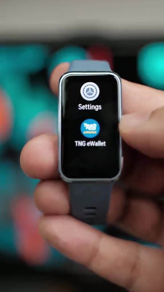 Huawei Band 10 di tangan menunjukkan menu Settings dan TNG eWallet di skrin