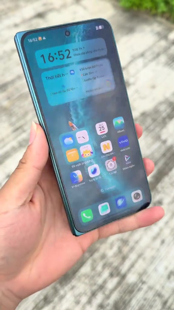 Màn hình chính OriginOS trên vivo X Fold6 với biểu tượng V-Appstore ở hàng dưới, cầm trên tay ngoài trời