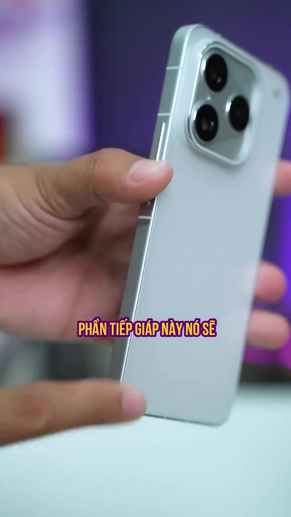 Mặt lưng iQOO 16 màu bạc với cụm ba camera và khung viền phẳng cầm trên tay