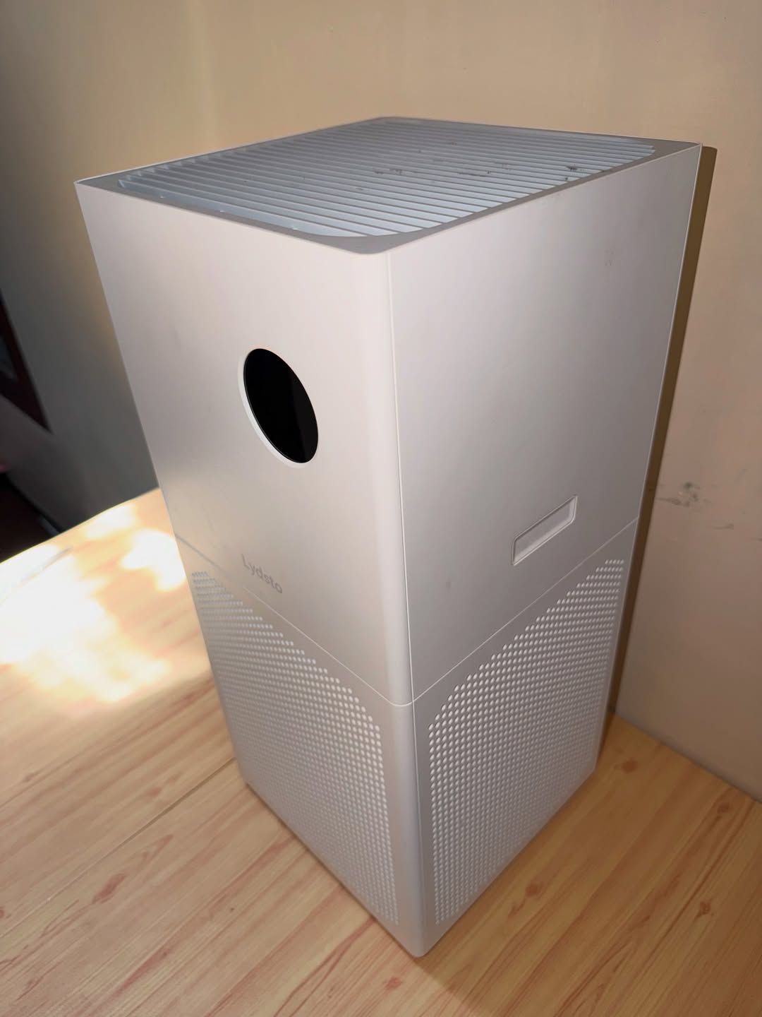 Pandangan atas air purifier putih menunjukkan gril keluaran udara di bahagian puncak unit