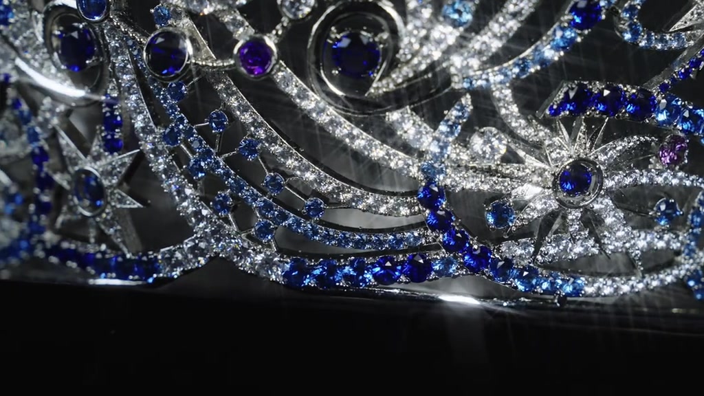 Chi tiết đá xanh lam và đá tím trên thân vương miện Miss Universe Vietnam 2026 quay cận cảnh trên nền đen