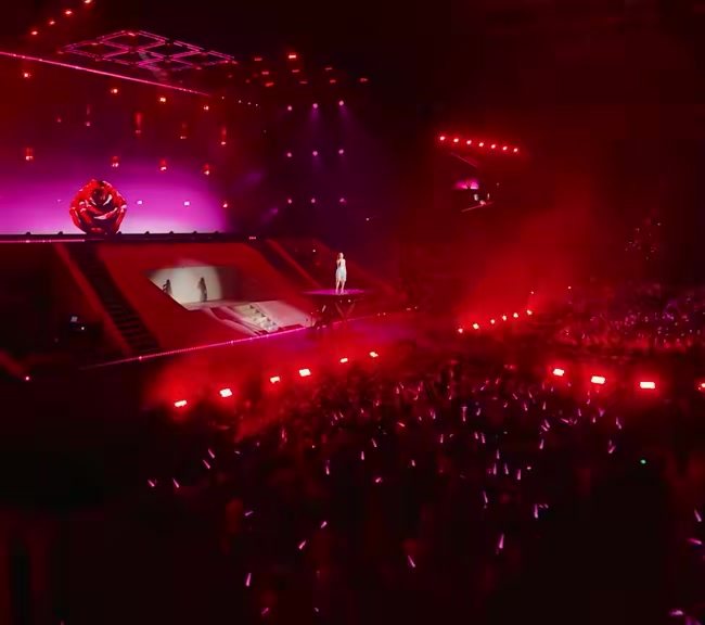 Sân khấu nhuốm đỏ của Phao Cứu Sinh Concert với một bóng ca sĩ trên bục nâng và khán đài dày đặc lightstick