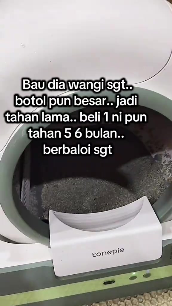 Kotak pasir kucing bertutup berwarna putih dan hijau dengan pasir kelabu di dalamnya