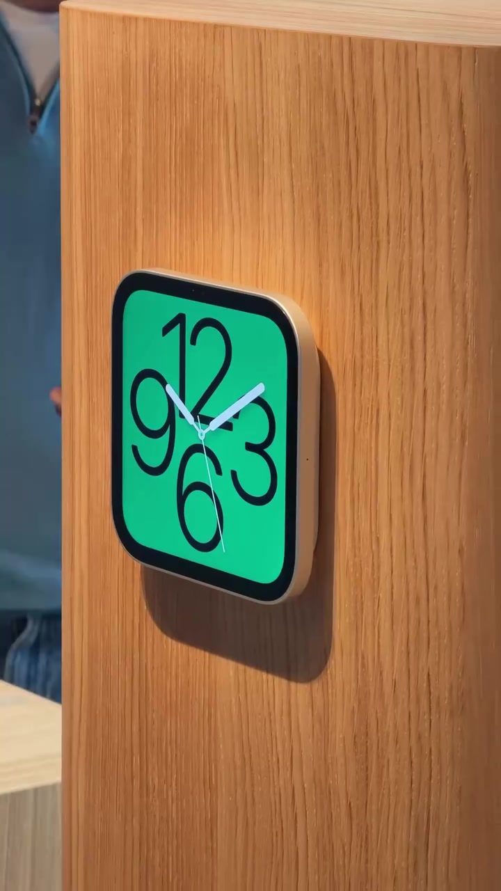 Apple HomeView bản gắn tường ốp trên cột gỗ, màn hình hiện mặt đồng hồ kim nền xanh lá