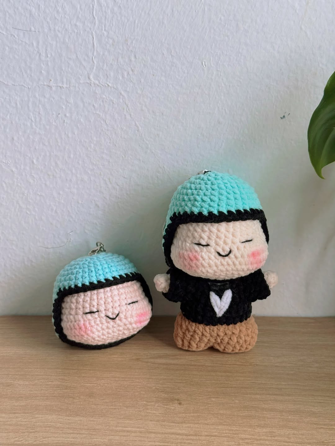 Hai móc khóa và búp bê móc len mũ xanh ngọc, áo đen mà fan làm theo hình tượng Hà An Huy để mang tới concert ATVNCG 2026