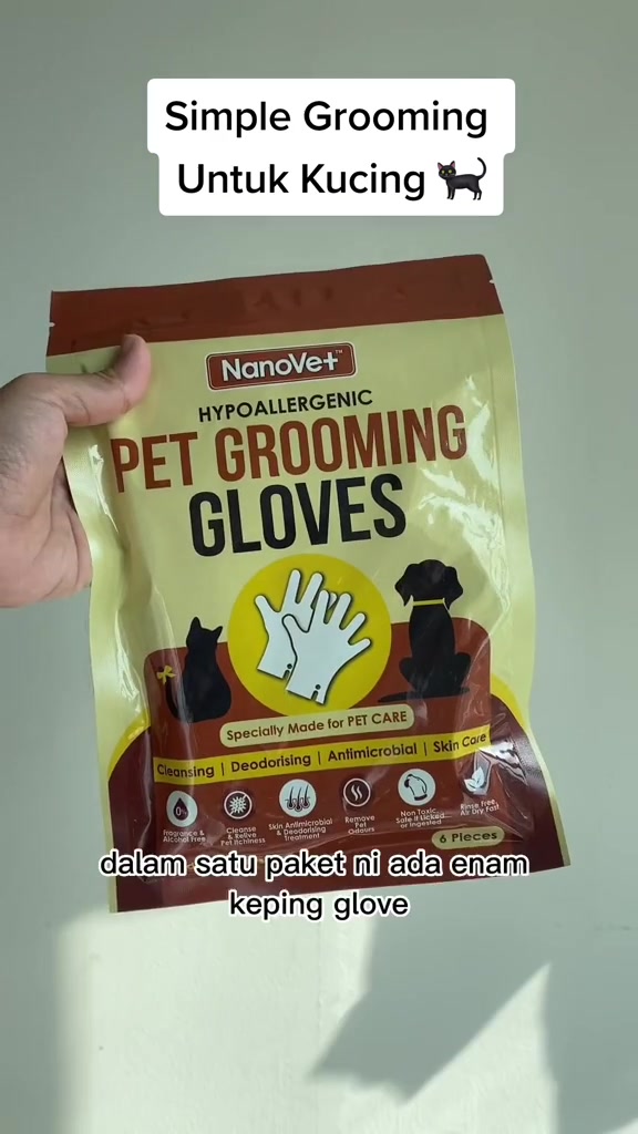 Tangan memegang pek NanoVet Pet Grooming Gloves berisi enam keping sarung tangan grooming kucing