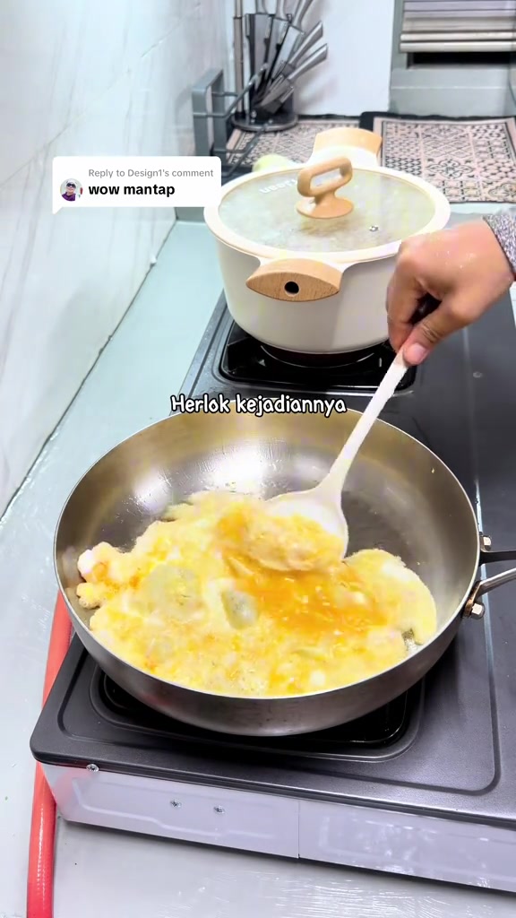 Telur dimasak dalam kuali stainless steel di atas dapur gas tanpa melekat