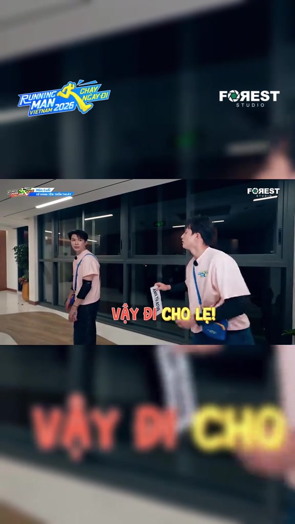 Thành viên cầm dải bảng tên màu trắng vừa lấy được trên tay trong hành lang kính trường quay