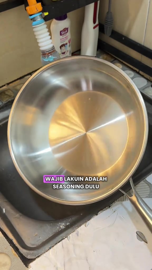 Kuali stainless steel bersih di dalam sinki sebelum proses seasoning