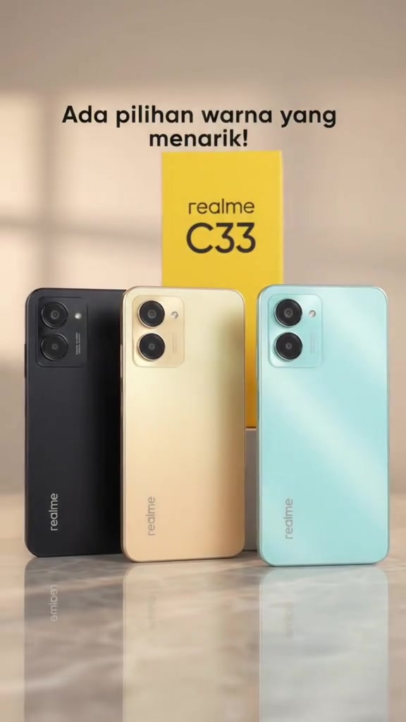 Tiga unit Realme C33 warna hitam, emas dan aqua berdiri di sebelah kotak kuning realme C33