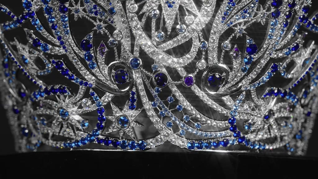 Cận cảnh thân vương miện Miss Universe Vietnam 2026 với đá trắng và đá xanh lam đan họa tiết ngôi sao trên nền tối