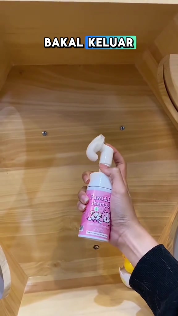 Botol dry shampoo kucing berwarna merah jambu dengan kepala berus silikon mengeluarkan buih