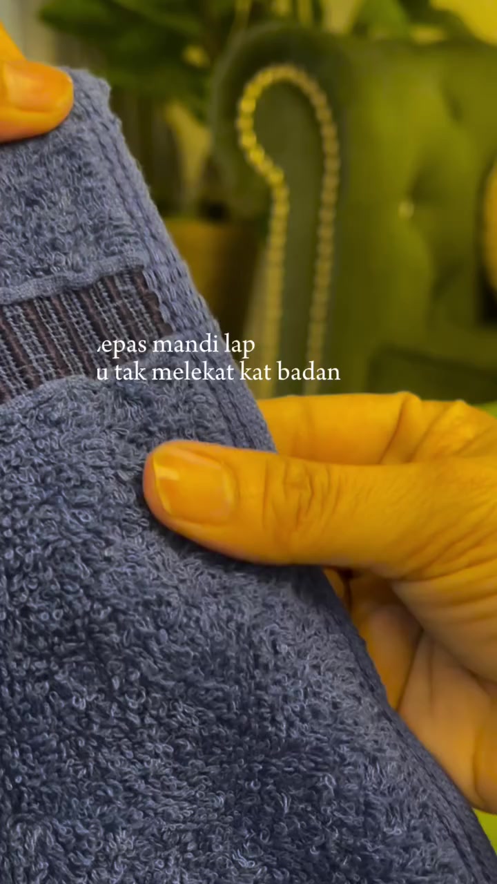 Jari mencubit bulu tuala cotton biru menunjukkan ketebalan seratnya