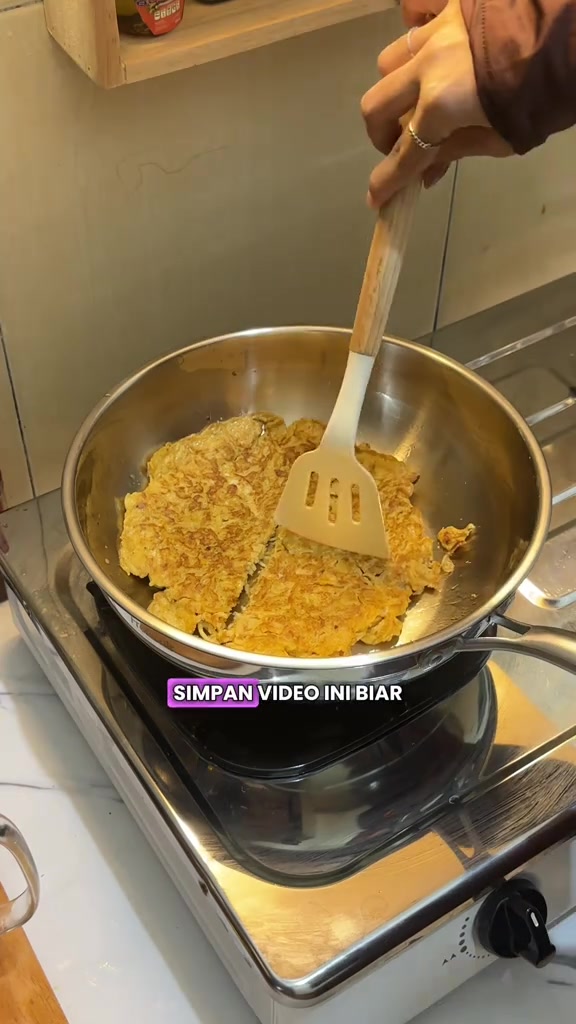 Telur dadah dimasak dalam kuali stainless steel selepas seasoning dengan spatula silikon