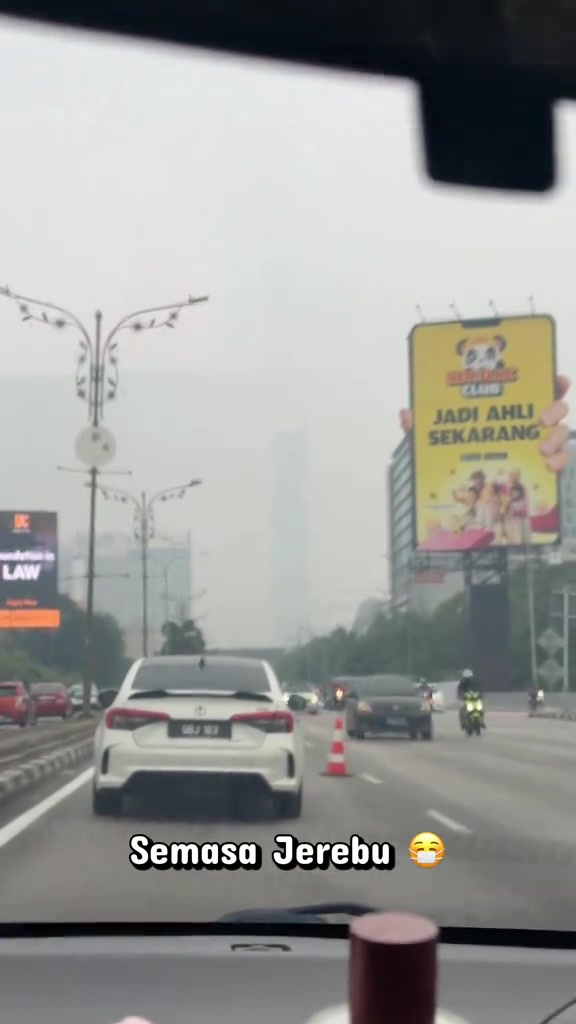 Jalan raya di Kuala Lumpur kelihatan kelabu dan berkabus tebal ketika jerebu, berbeza dengan langit biru sebelum jerebu