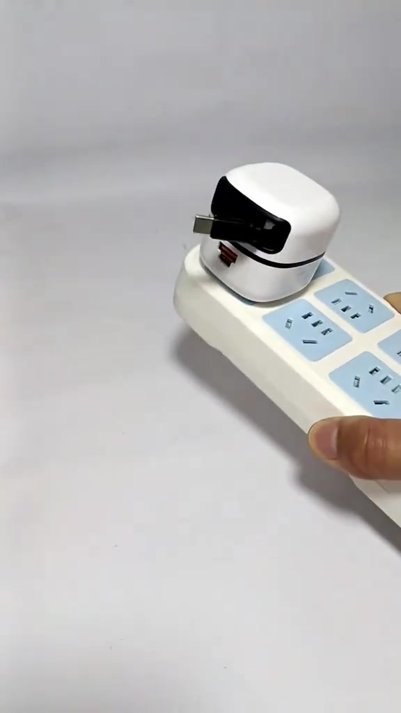 Một củ sạc nhỏ gọn màu trắng cắm trên ổ cắm kéo dài nhiều cổng