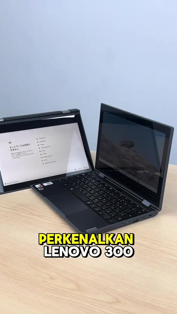 Dua unit Lenovo 300e Chromebook hitam terbuka di atas meja kayu