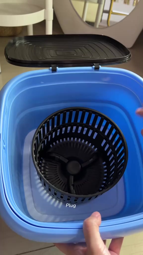 Bahagian dalam tab mesin basuh mini biru dengan bakul spinner hitam dan penutup hitam terbuka