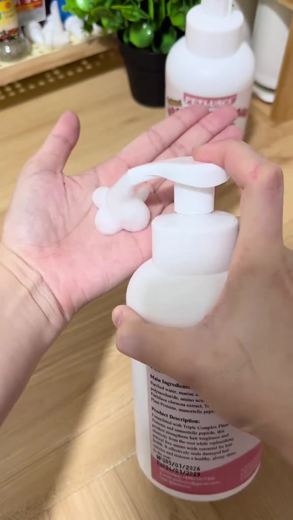 Buih putih dipam keluar dari botol foam mandian kucing ke atas tapak tangan