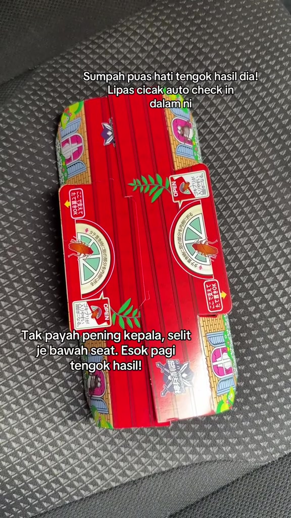 Perangkap lipas lekit berwarna merah diletakkan di atas tempat duduk kain dalam kereta