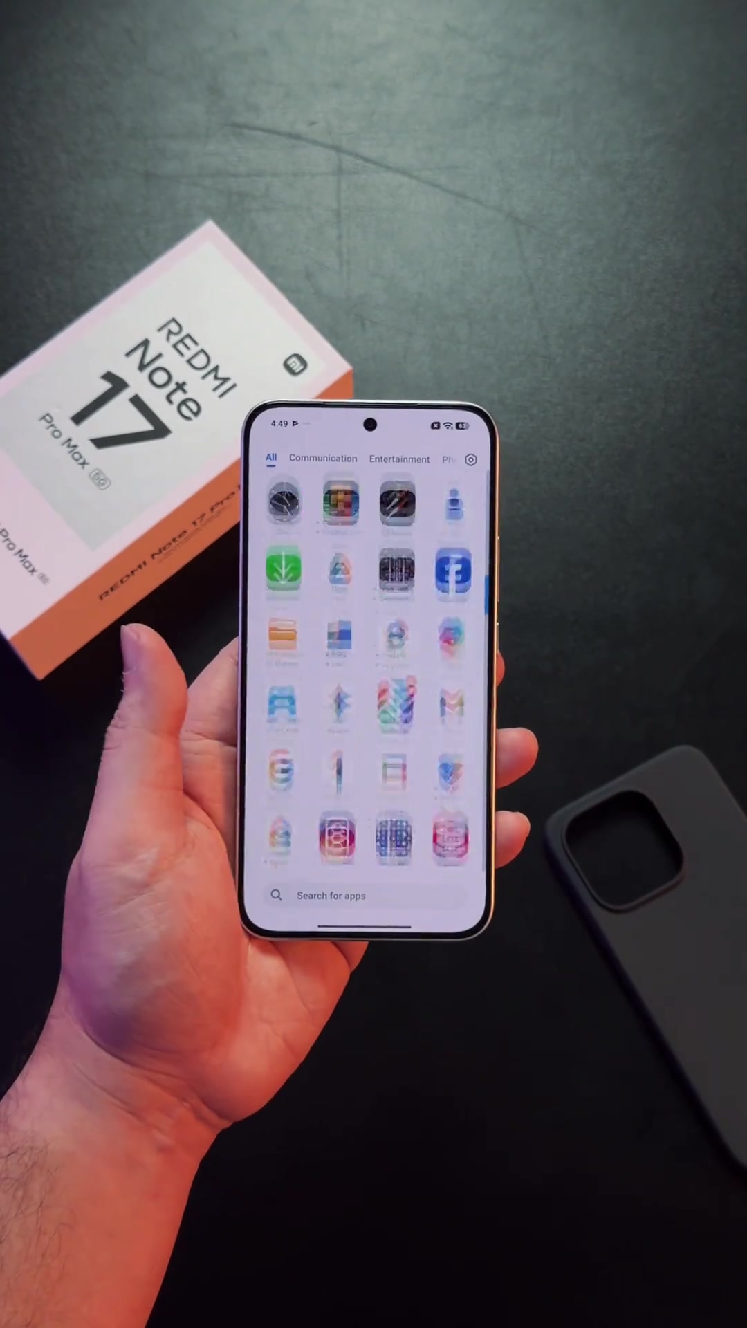 Redmi Note 17 Pro Max 5G dipegang dengan skrin menyala di sebelah kotak rasminya
