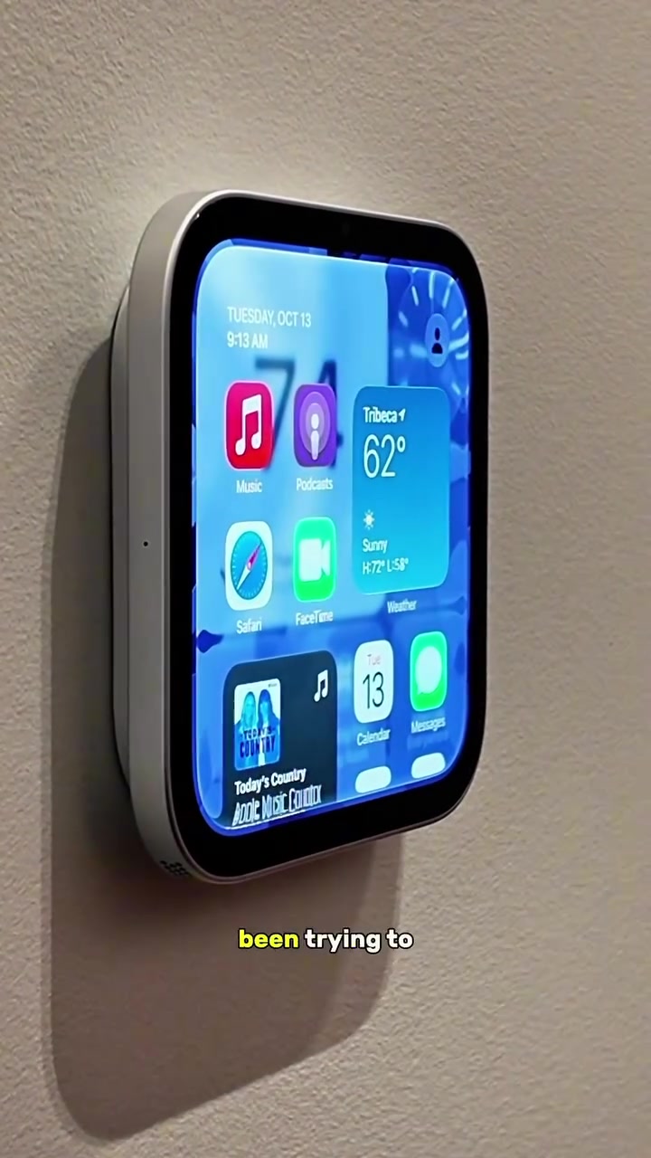 Apple HomeView bản gắn tường trên tường sơn, màn hình chính hiện các ứng dụng Music, Podcasts, Safari, FaceTime cùng widget thời tiết và lịch