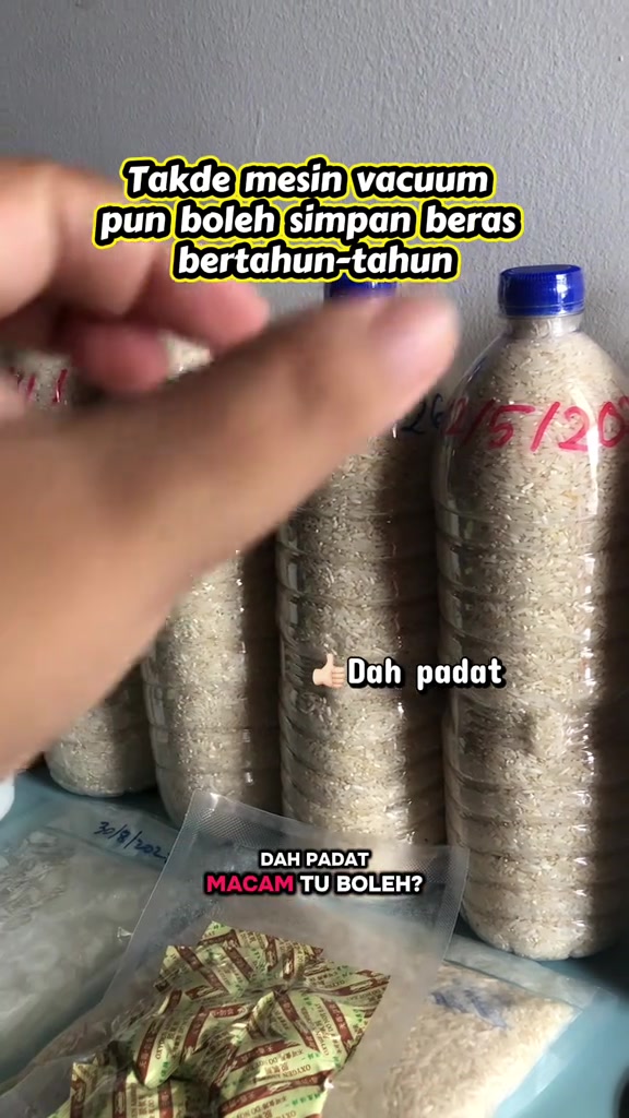 Tangan menunjuk botol beras yang sudah padat, dengan pek penyerap oksigen kelihatan di hadapan