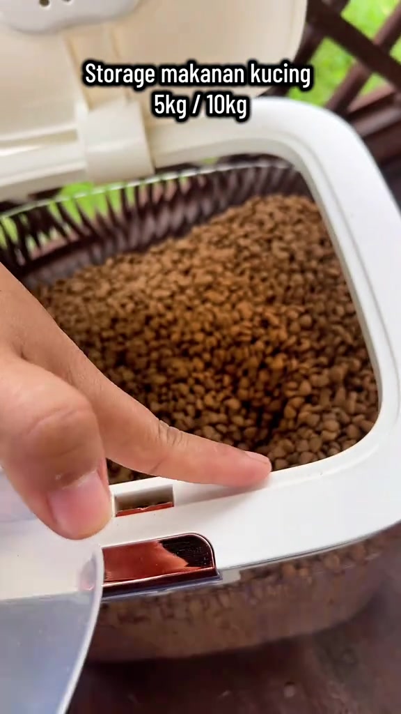 Jari menekan butang penutup bekas kedap udara yang penuh dengan kibbles