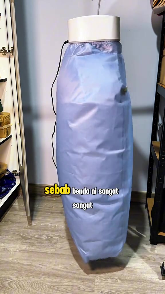 Mesin pengering portable jenis beg kain tergantung di sudut bilik antara dua rak